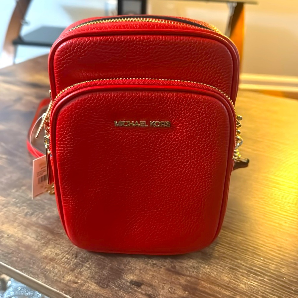 MICHEL KORS, NWT. Red leather. Never used. The tag is there—phone/Wallet/Keys.